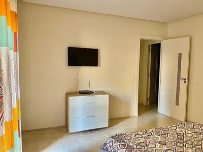 a bedroom with a bed and a flat screen tv at Apparemment 1 chambre salon à coté de la gare guéliz 20 in Marrakech