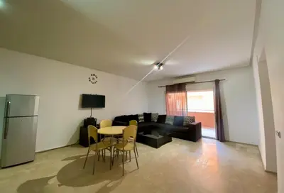 a living room with a couch and a table and chairs at Apparemment 1 chambre salon à coté de la gare guéliz 16 in Marrakech