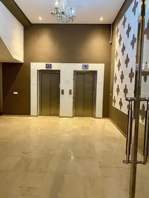 an empty lobby with three elevators and a flag at Apparemment 1 chambre salon à coté de la gare guéliz 16 in Marrakech