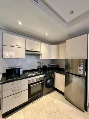 a kitchen with white cabinets and a dishwasher at Appartement 2 chambres salon à coté de carré éden 10 in Marrakech