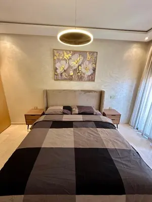 a bedroom with a large bed and a painting on the wall at Appartement 2 chambres salon à coté de carré éden 10 in Marrakech