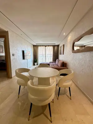 a living room with a table and chairs and a couch at Appartement 2 chambres salon à coté de carré éden 10 in Marrakech