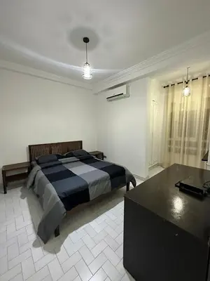 a bedroom with a bed and a table in it at Appartement 3 chambres salon à coté de éden et Mcdo 6 in Marrakech