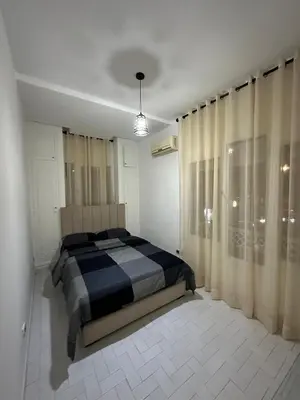a bedroom with a bed and a large window at Appartement 3 chambres salon à coté de éden et Mcdo 6 in Marrakech
