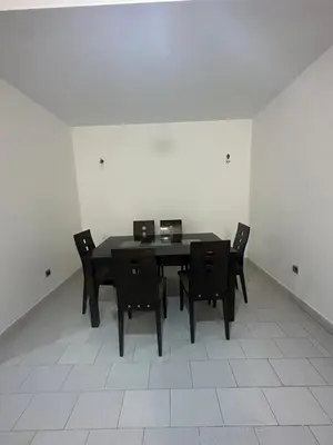 a dining room with a black table and chairs at Appartement 3 chambres salon à coté de éden et Mcdo 6 in Marrakech