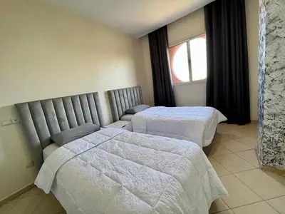 a hotel room with two beds and a window at Appartement 2 chambres salon à coté de la gare centre de guéliz 21 in Marrakech