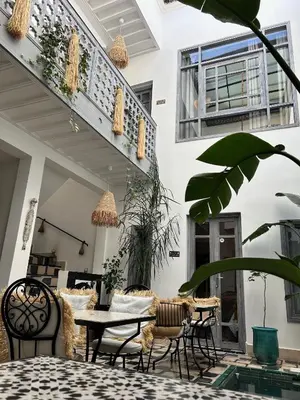 a patio with a table and chairs and a building at Riad Be Colors in Marrakech