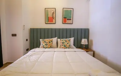 a bedroom with a large white bed with two pillows at Charmant appartement in Marrakech
