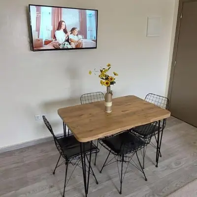 a wooden table with chairs and a tv on the wall at Apartment in Marrakech - WiFI - IPTV Movies - equipped - free parking in Marrakech