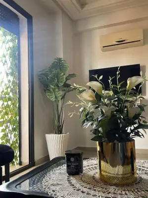 a vase with flowers on a table in a room at Superbe studio en plein centre in Marrakech