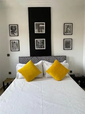 a bedroom with a white bed with yellow pillows at Superbe studio en plein centre in Marrakech