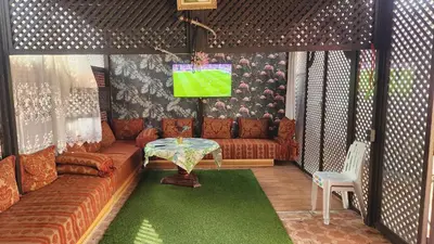 a living room with a couch and a tv at Appartement Riad 5min à pied de l'aéroport in Marrakech