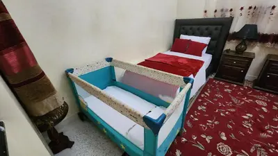 a bedroom with two twin beds and a red blanket at Appartement Riad 5min à pied de l'aéroport in Marrakech