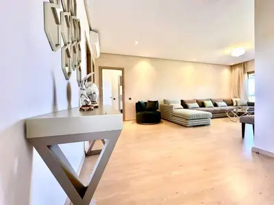 a living room with a couch and a table at Appartement Spacieux et Moderne avec une Vue sur Montagne et Piscine in Marrakech