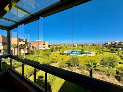 a large window in a building with a view of a park at Appartement Spacieux et Moderne avec une Vue sur Montagne et Piscine in Marrakech