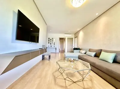 a living room with a couch and a table at Appartement Spacieux et Moderne avec une Vue sur Montagne et Piscine in Marrakech