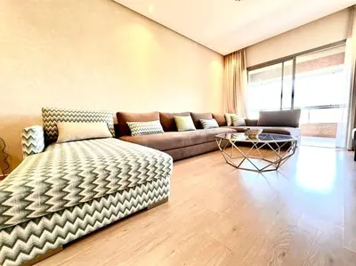 a living room with a couch and a table at Appartement Spacieux et Moderne avec une Vue sur Montagne et Piscine in Marrakech