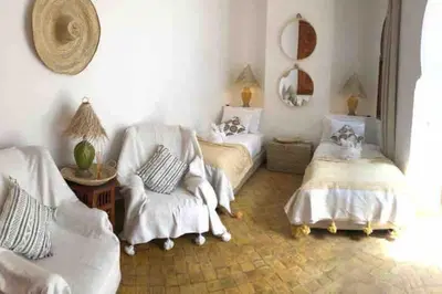 a living room with two beds and a chair at Riad Aslan Place des épices - en exclusivité, wifi in Marrakech