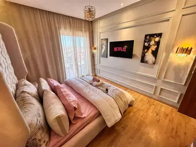 a bed with pillows on it in a room at Appartement Luxueux avec Piscine 10 minutes du centre ville in Marrakech