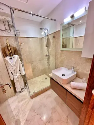 a bathroom with a shower and a sink and a toilet at Appartement Luxueux avec Piscine 10 minutes du centre ville in Marrakech