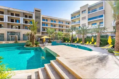 a swimming pool in front of a building at Appartement Luxueux avec Piscine 10 minutes du centre ville in Marrakech