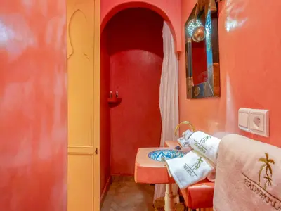 a room with red walls and a table with towels at Riad Nakhla in Marrakech