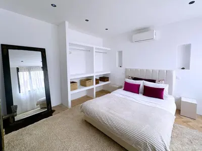 a bedroom with a bed with pink pillows and a mirror at Villa Jassmin, piscine, à 6km du centre ville in Marrakech
