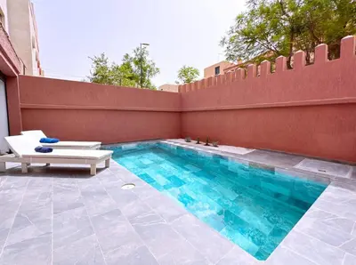 a swimming pool with two chairs and a fence at Villa Jassmin, piscine, à 6km du centre ville in Marrakech