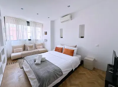 a white bedroom with a large bed and a couch at Villa Jassmin, piscine, à 6km du centre ville in Marrakech