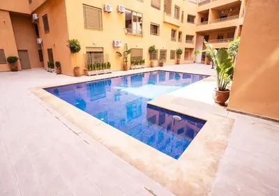 a swimming pool in the courtyard of a building at Appartement à louer Marrakech in Marrakech