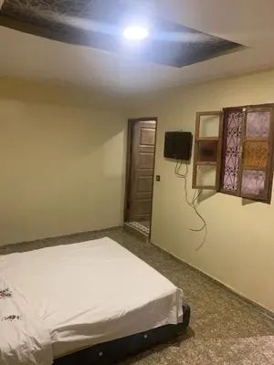 a bedroom with a bed and a tv on the wall at Maison coco in Marrakech