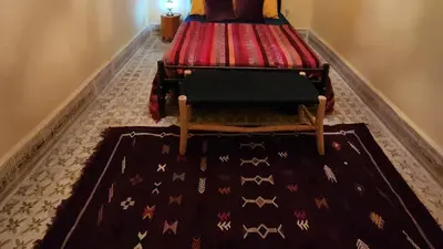a room with two beds with a rug on the floor at Riad Sleeps 2 with Rooftop Views in Marrakech
