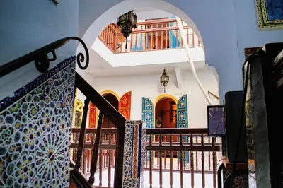 a staircase in a building with books on a shelf at Riad - In Medina - Kesh Design in Marrakech