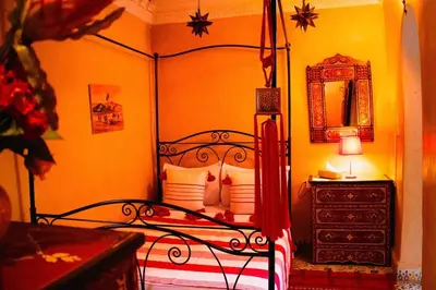 a bedroom with a black bed and a dresser with a mirror at Riad - In Medina - Kesh Design in Marrakech