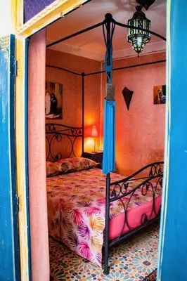 a bedroom with a canopy bed with a colorful comforter at Riad - In Medina - Kesh Design in Marrakech