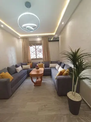 a living room with a blue couch and a table at Appartement Mima Marrakech Proche centre ville, cosy et spacieux in Marrakech