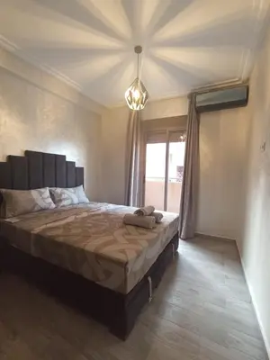 a bedroom with a large bed with a large window at Appartement Mima Marrakech Proche centre ville, cosy et spacieux in Marrakech
