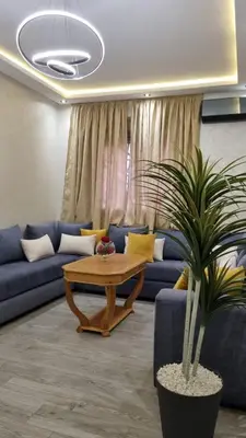 a living room with a blue couch and a table at Appartement Mima Marrakech Proche centre ville, cosy et spacieux in Marrakech