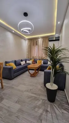 a living room with a couch and a table at Appartement Mima Marrakech Proche centre ville, cosy et spacieux in Marrakech
