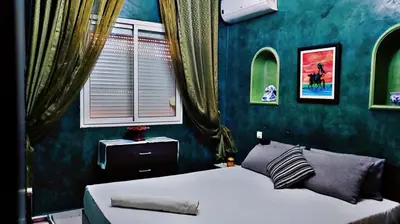 a bedroom with a bed and a green wall at Cozy Bedroom Sidi maarouf in Marrakech