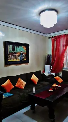 a living room with a black couch and a table at Cozy Bedroom Sidi maarouf in Marrakech