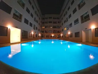 a large swimming pool with blue lights in a building at Nour 5 in Marrakech