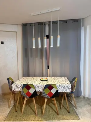 a dining room with a table with chairs and a chandelier at Nour 5 in Marrakech