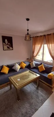 a living room with a blue couch with yellow pillows at Résidence Nadia 3 étage appartement 22 in Marrakech