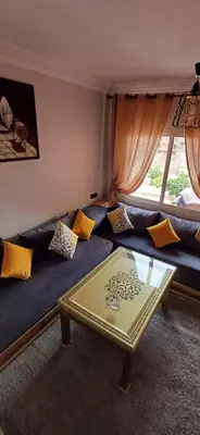 a living room with a blue couch and a table at Résidence Nadia 3 étage appartement 22 in Marrakech