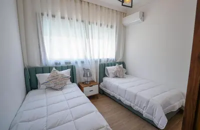 a bedroom with two beds and a window at Spacieux et luxueux appartement in Marrakech