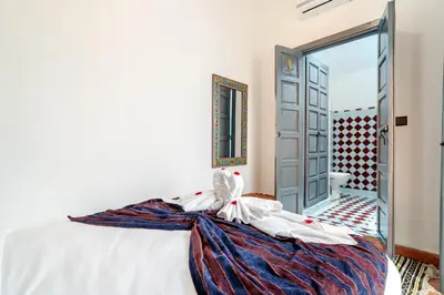 a bedroom with a bed and an open door at Riad La Kasbah secrète - Piscine intérieure in Marrakech
