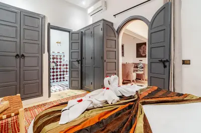 a bedroom with a large bed with white sheets at Riad La Kasbah secrète - Piscine intérieure in Marrakech