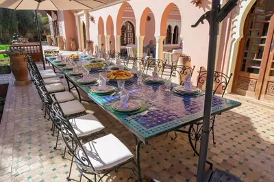 a long table with chairs and plates of food on it at Villa Riad luxe centre marrakech majorelle Rue Yves st laurent in Marrakech