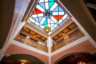 a stained glass ceiling in a building with a wine rack at Riad Brothers in Marrakech